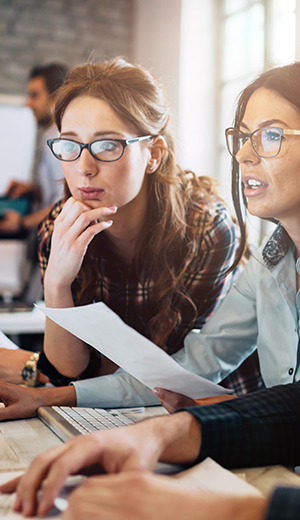 two women looking at computer discussing
